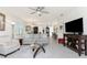 Open-concept living room with tile floors, comfortable seating, and a ceiling fan, connecting to the dining and kitchen areas at 7304 W Lenox Circle, Punta Gorda, FL 33950
