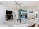 Bright living room featuring neutral decor, tile floors, and sliding glass doors to the outdoor living space at 7304 W Lenox Circle, Punta Gorda, FL 33950