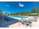 A luxurious swimming pool area with lounge chairs, tables, and lush landscaping for relaxation and enjoyment at 7304 W Lenox Circle, Punta Gorda, FL 33950