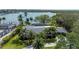 Aerial shot of property with lush landscaping, mature trees, and waterfront access to the tranquil bay at 75 Spyglass Aly, Placida, FL 33946