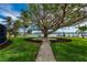 Expansive backyard featuring a mature tree, waterside lounging, and lush landscaping at 75 Spyglass Aly, Placida, FL 33946