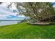 Well-maintained lawn featuring a mature shade tree and views of the water at 75 Spyglass Aly, Placida, FL 33946