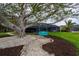 Backyard featuring a mature tree with a swing and spacious lawn near the screened in lanai at 75 Spyglass Aly, Placida, FL 33946