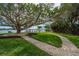 A sprawling lawn leads to the water from a well-manicured yard with mature trees at 75 Spyglass Aly, Placida, FL 33946