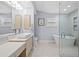 Bathroom with dual vanities, a glass shower, and separate soaking tub at 75 Spyglass Aly, Placida, FL 33946