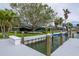 Dock with a boat lift leading to a lush lawn and serene waterfront views surrounded by mature trees at 75 Spyglass Aly, Placida, FL 33946