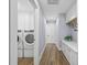 This laundry area features white cabinets, a bench, and wood floors at 75 Spyglass Aly, Placida, FL 33946