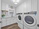 Bright laundry area with modern appliances, white cabinets, and sink at 75 Spyglass Aly, Placida, FL 33946