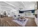 Bright living room featuring stone fireplace, wood flooring, and open access to the kitchen area at 75 Spyglass Aly, Placida, FL 33946