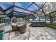 A screened-in pool area with a hot tub, patio furniture, and views of the water at 75 Spyglass Aly, Placida, FL 33946