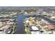 Aerial view of a waterfront community, showcasing the canal, swimming pools, and well-maintained homes at 944 Genoa Ct, Punta Gorda, FL 33950