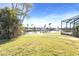Picturesque backyard with waterfront views, lush landscaping, and a screened-in lanai at 944 Genoa Ct, Punta Gorda, FL 33950