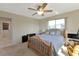 Bedroom with a wood-framed bed, a ceiling fan, a window, and light colored carpet flooring at 944 Genoa Ct, Punta Gorda, FL 33950