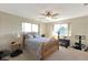 Bright bedroom with a wooden bed frame, two windows, ceiling fan, and carpet floors at 944 Genoa Ct, Punta Gorda, FL 33950
