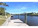 Scenic view of a private dock with wooden posts and a concrete deck, perfect for relaxing by the water at 944 Genoa Ct, Punta Gorda, FL 33950