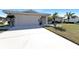 Front exterior of a well-maintained home with a large driveway, attached garage, and neat landscaping at 944 Genoa Ct, Punta Gorda, FL 33950