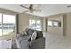 Bright living room with tile floors, ceiling fan, and water views from the large windows at 944 Genoa Ct, Punta Gorda, FL 33950