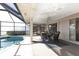 Covered patio with a dining table and screened enclosure, offering a serene outdoor living space by the pool at 944 Genoa Ct, Punta Gorda, FL 33950
