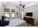Bedroom featuring a ceiling fan, natural light and view to balcony with pool at 99 Vivante Blvd # 404, Punta Gorda, FL 33950