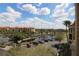 View of community featuring well-manicured landscapes, a pond, and building parking at 99 Vivante Blvd # 404, Punta Gorda, FL 33950