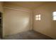 Garage space featuring unfinished concrete floor, beige painted walls, small windows, and pipes at 99 Vivante Blvd # 404, Punta Gorda, FL 33950