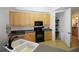 Functional kitchen with ample storage space, black appliances, and light wood cabinets at 99 Vivante Blvd # 404, Punta Gorda, FL 33950