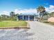 Charming single-story home featuring a metal roof, palm trees and a decorative stone driveway at 1027 Campbell St, Port Charlotte, FL 33953