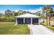 Charming home with a white metal roof and a well manicured front yard at 1027 Campbell St, Port Charlotte, FL 33953