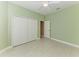 Neutral bedroom with a ceiling fan, large closet, an ensuite door, and neutral paint and tile at 1368 Grebe Dr, Punta Gorda, FL 33950