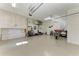 Spacious garage with epoxy floor, ceiling fan, overhead storage, tools, refrigerator, and motorcycle at 1368 Grebe Dr, Punta Gorda, FL 33950