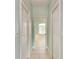 Hallway with white trim and doors, tile flooring, leading to a bedroom with a window at 1368 Grebe Dr, Punta Gorda, FL 33950