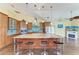 Kitchen featuring an island with bar stool seating, modern appliances, wooden cabinetry, and a ceiling fan at 1368 Grebe Dr, Punta Gorda, FL 33950