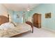 Bright main bedroom featuring a ceiling fan, light blue walls, tile flooring, and decorative wooden armoire at 1368 Grebe Dr, Punta Gorda, FL 33950