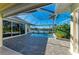Screened pool with brick pavers, view of the water, and surrounding landscaping at 1368 Grebe Dr, Punta Gorda, FL 33950