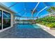 Screened in pool with water views, a brick patio, and lush tropical landscaping at 1368 Grebe Dr, Punta Gorda, FL 33950