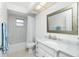 Bathroom featuring a marble-top vanity, a framed mirror, and a shower/tub with a white shower curtain at 14195 Brisk Ave, Port Charlotte, FL 33953