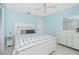 Serene light blue bedroom with a queen bed, white furniture, and natural light at 14195 Brisk Ave, Port Charlotte, FL 33953