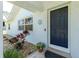 Home featuring a blue door, decorative flower pot, and tasteful landscaping with rocks at 14195 Brisk Ave, Port Charlotte, FL 33953