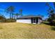 Exterior view of backyard featuring a screened patio and lush lawn at 160 Green Pine Park, Rotonda West, FL 33947