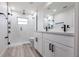 Modern bathroom features double vanity, glass shower with black hardware, and wood-look flooring at 160 Green Pine Park, Rotonda West, FL 33947