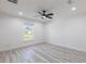 Bright bedroom with white walls, light wood-look floors, a ceiling fan, and a view of the outdoors through a window at 160 Green Pine Park, Rotonda West, FL 33947