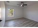 Bright bedroom with a ceiling fan, wood-look floors, and a window with a view of palm trees at 160 Green Pine Park, Rotonda West, FL 33947