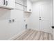 Neat laundry room with upper cabinets, utility sink hookup, and new wood-look floors at 160 Green Pine Park, Rotonda West, FL 33947
