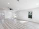 Neutral living area with light colored wood-look floors, a large black ceiling fan and large bright windows at 160 Green Pine Park, Rotonda West, FL 33947