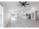 Open-concept living area showcasing light laminate flooring, a modern ceiling fan, and a seamless transition to the adjacent kitchen at 160 Green Pine Park, Rotonda West, FL 33947