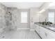 Bright bathroom featuring a double vanity with granite counters and a large walk-in shower with marble tiling at 16271 Branco Dr, Punta Gorda, FL 33955