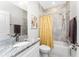 Bathroom with gray-tiled shower, white cabinetry, granite countertop, and a mirror above the sink at 16271 Branco Dr, Punta Gorda, FL 33955