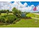 Community entrance sign amidst lush landscaping and an American flag at 16271 Branco Dr, Punta Gorda, FL 33955