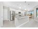 Modern kitchen boasts white cabinets, stainless steel appliances, and an island with gray countertops at 16271 Branco Dr, Punta Gorda, FL 33955