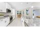 Bright kitchen featuring stainless steel appliances and an adjacent dining area with views of the pool at 16271 Branco Dr, Punta Gorda, FL 33955